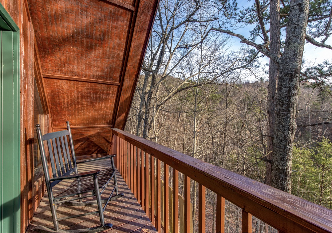 Unwind in your private rocking chair while soaking in peaceful forest views from this cozy covered balcony.