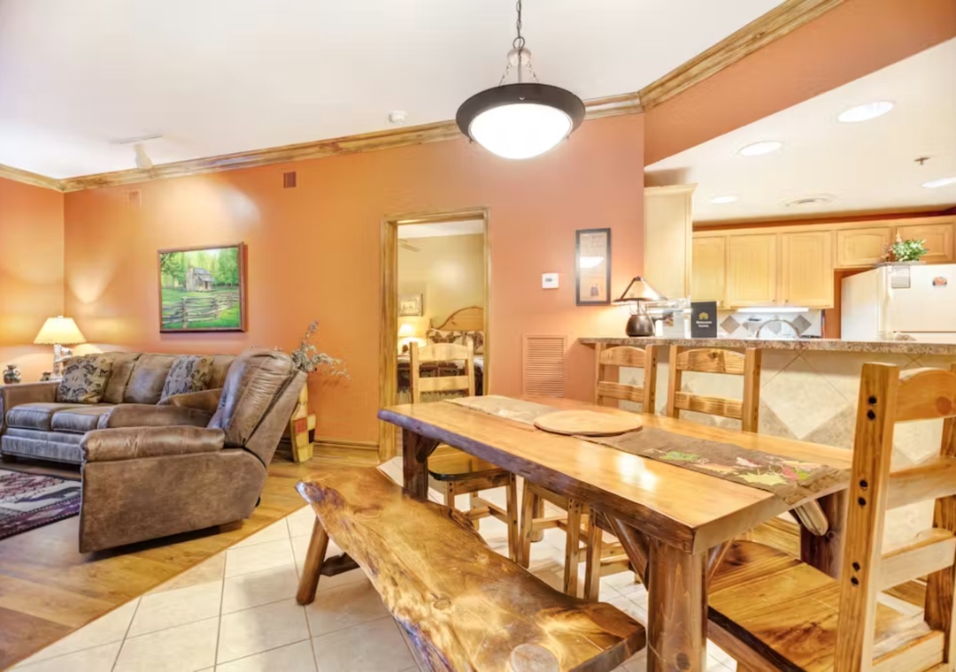 Unwind in your spacious open-plan living area featuring a cozy sectional sofa and rustic dining table perfect for family meals.