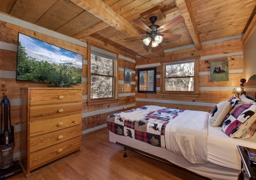 Drift off in your cozy log cabin bedroom where rustic charm meets modern comfort, complete with forest views and peaceful ambiance.