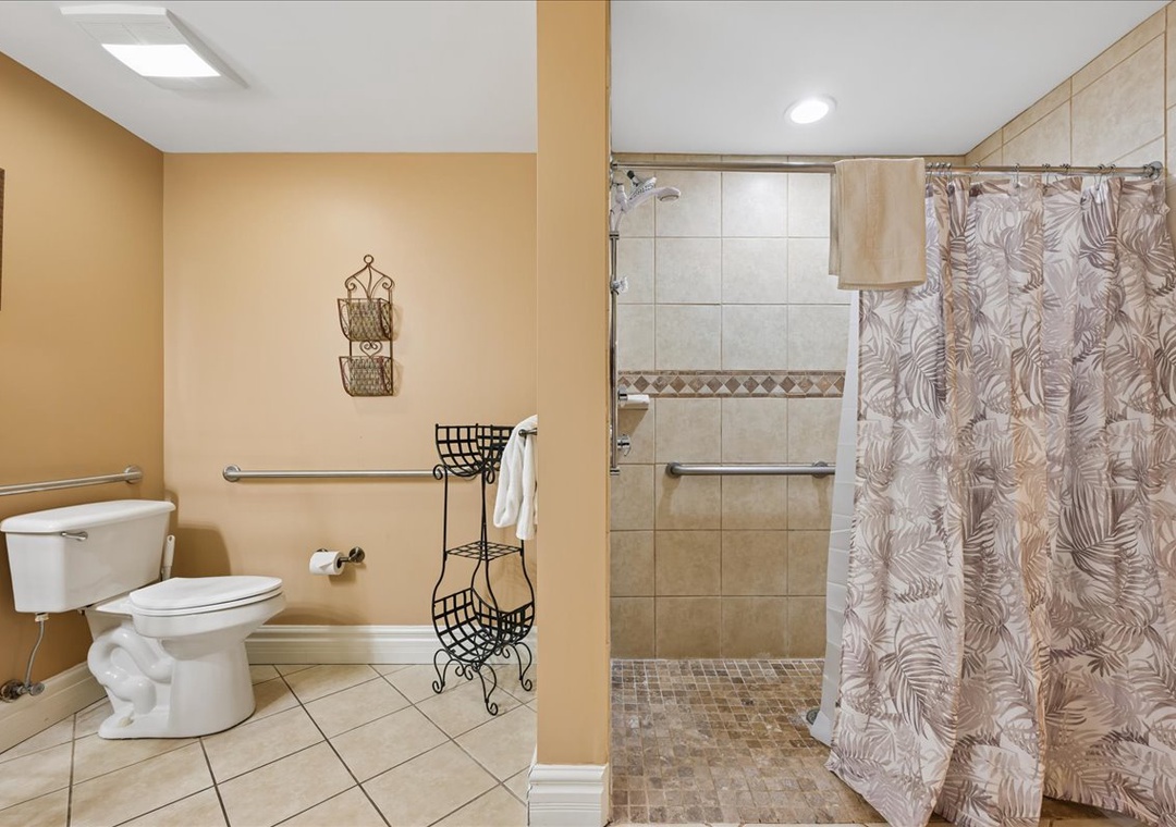 Your private bathroom features a spacious tiled shower with grab bars and accessible design for your comfort and safety.