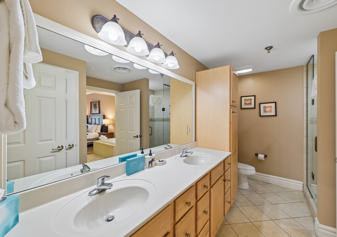 Spacious bathroom with dual sinks offers plenty of room to get ready, while bright vanity lighting creates the perfect ambiance for your daily routine.