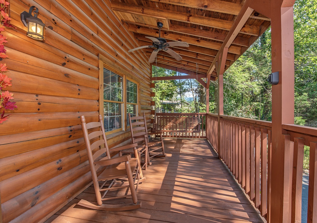 Settle into your rocking chair on this covered porch and breathe in the crisp mountain air. Surrounded by lush forest, you'll unwind to the gentle sway and the soothing sounds of nature.