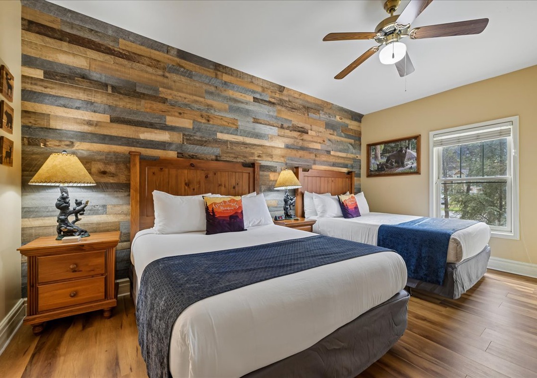 Unwind in your cozy retreat with rustic wood accent walls and comfortable twin beds perfect for restful nights.