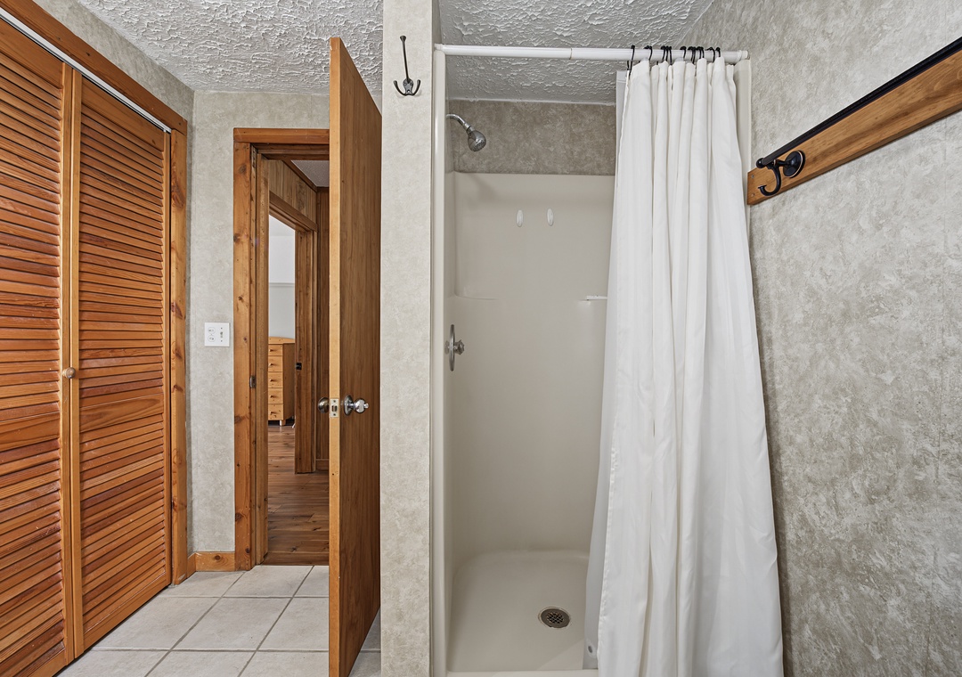 Step into your private bathroom where warm wood tones meet modern convenience. A spacious walk-in shower awaits, complete with fresh linens and thoughtful touches for your comfort.