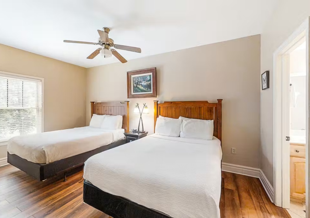 Rest peacefully in your comfortable bedroom with twin beds, warm wood accents, and gentle ceiling fan keeping you cool.