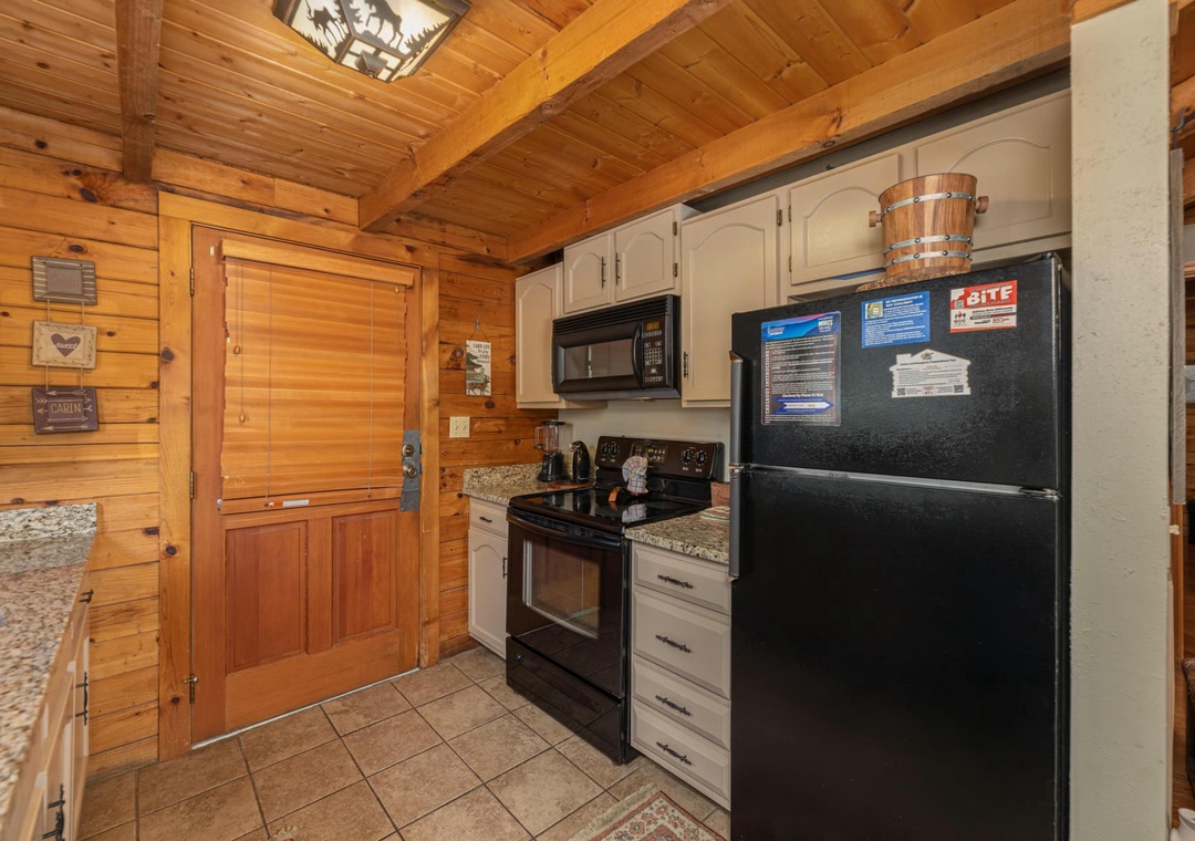 Your fully equipped kitchen features granite countertops, modern appliances, and warm wood finishes that make meal prep a cozy, inviting experience during your mountain getaway.