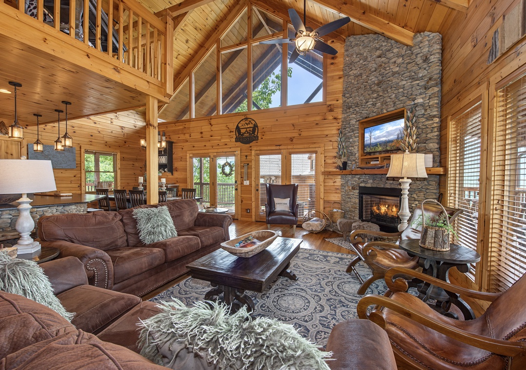 Sink into plush leather sofas in this soaring great room, where warm wood beams frame mountain views and a crackling stone fireplace invites you to unwind.