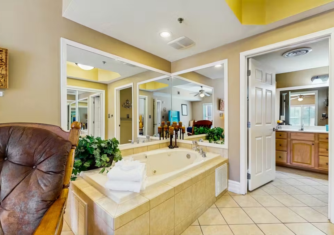 Luxurious master suite with jetted soaking tub surrounded by mirrors - your perfect retreat for romantic evenings and rejuvenating baths.