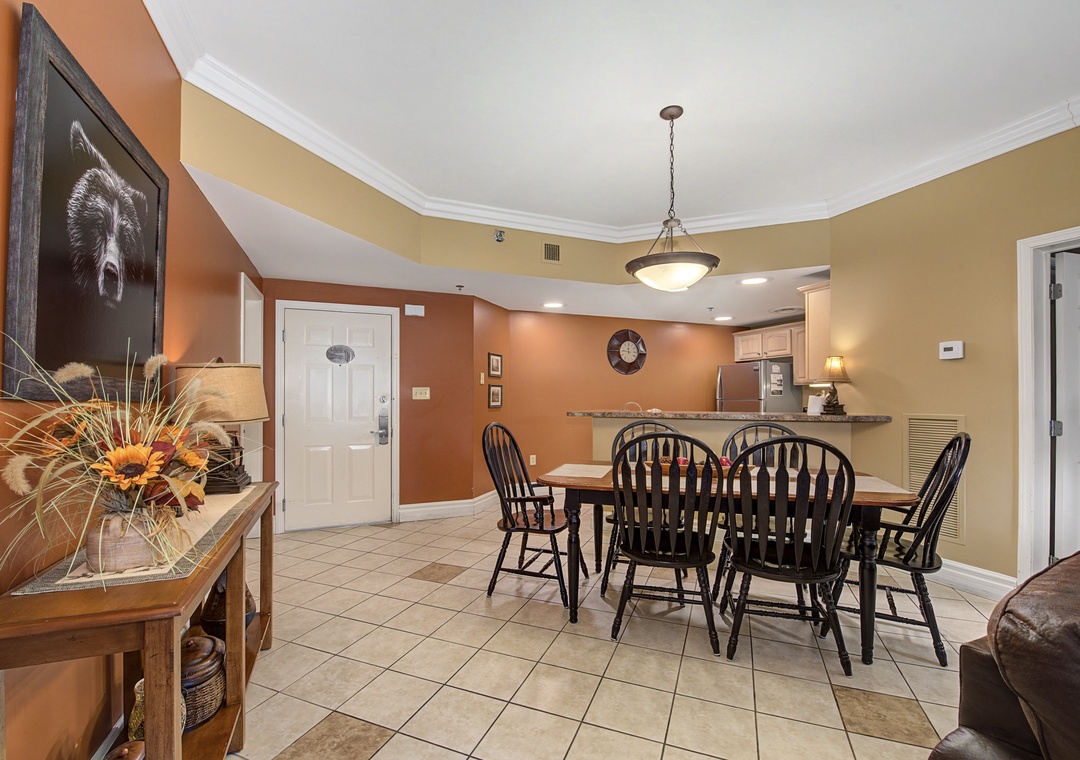 Your open dining area invites family meals with warm wood chairs around a spacious table, connected to your fully equipped kitchen.