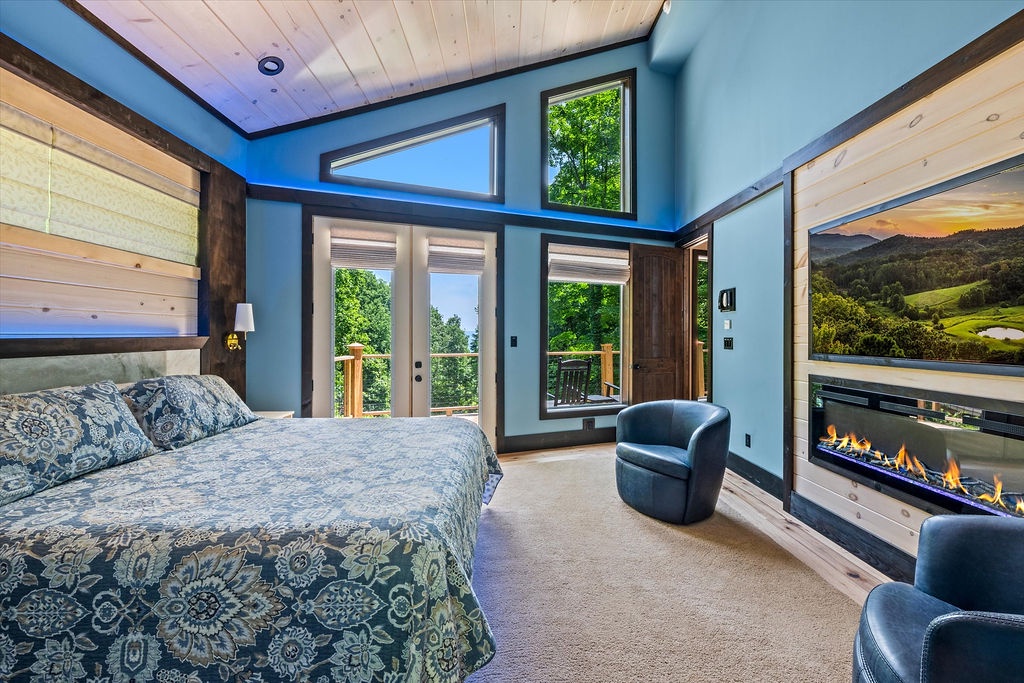 Sink into the plush bed and let the fireplace warm your retreat. French doors open to your private balcony, framing lush greenery and peaceful views.