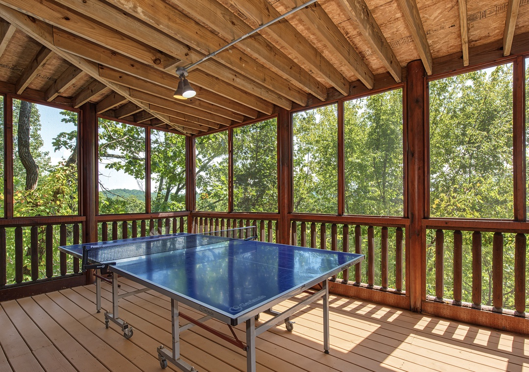 Challenge your travel companions to a friendly match on this screened porch, where tree-framed mountain views set the stage for unforgettable games and laughter.