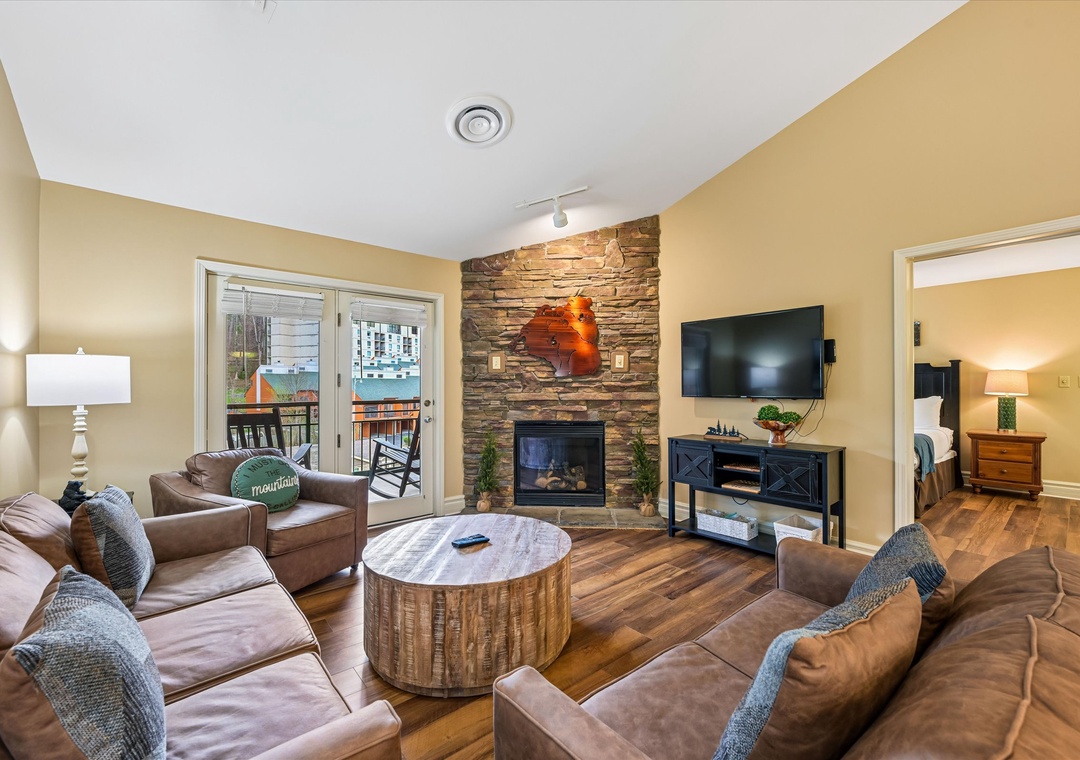 Sink into plush leather seating by your stone fireplace, where warmth meets modern comfort in this inviting living space.