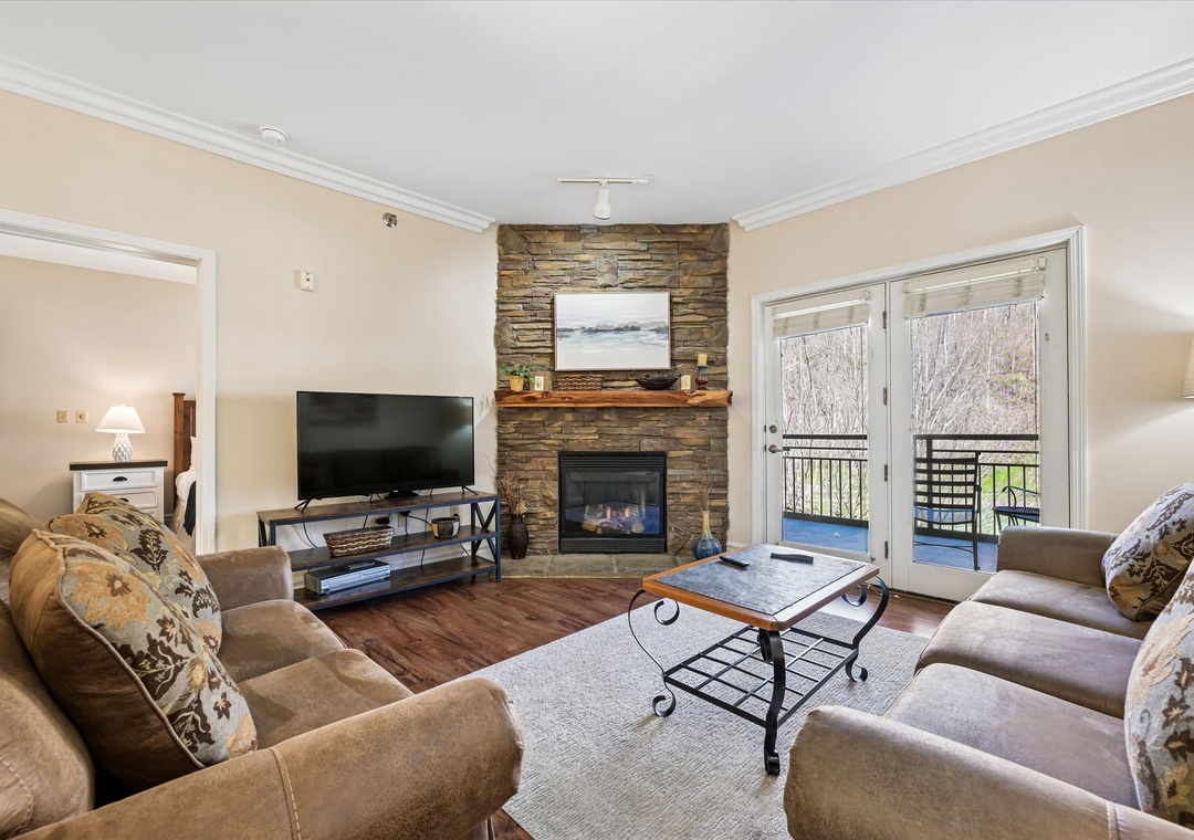 Cozy up by your stone fireplace in this comfortable living room, where plush seating and warm ambiance create the perfect retreat.