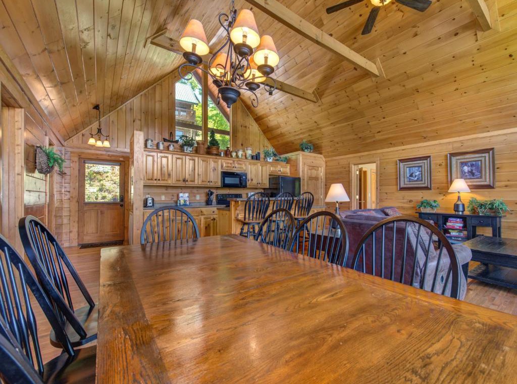 Gather around this rustic dining table where your group can share meals beneath soaring wood-beam ceilings and warm chandelier light.