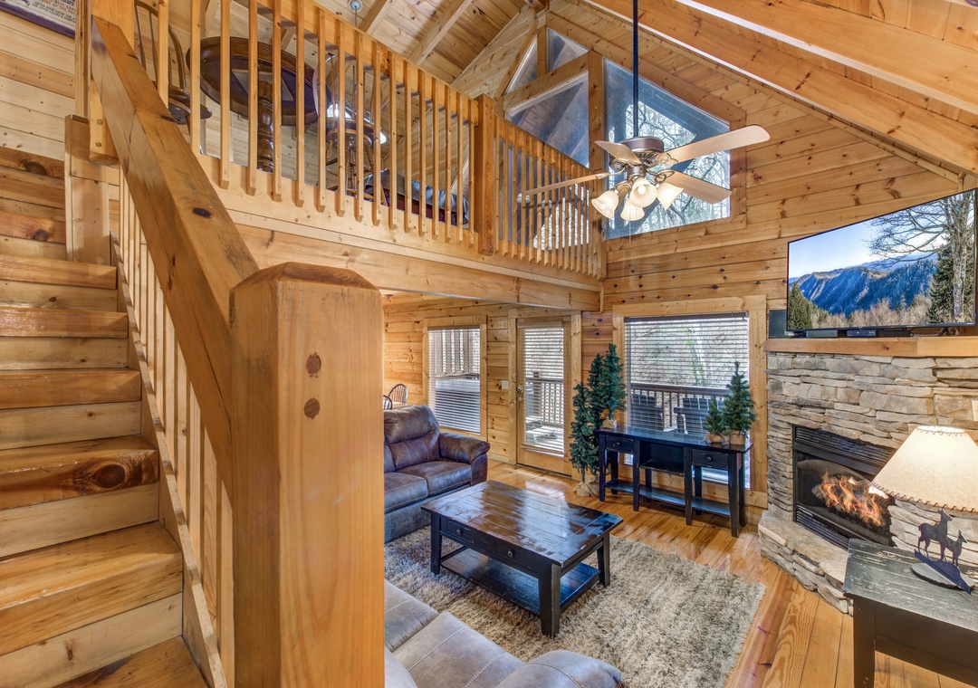 Unwind in this stunning log cabin living room where rustic charm meets modern comfort, complete with soaring ceilings and a cozy stone fireplace.
