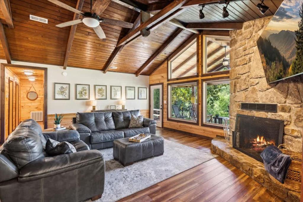 Sink into plush leather seating beside your crackling stone fireplace, beneath soaring wood-beam ceilings that fill your retreat with mountain-lodge warmth.