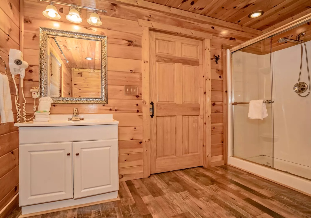 Warm wood walls create a cozy cabin atmosphere while you enjoy modern amenities in your private bathroom retreat.