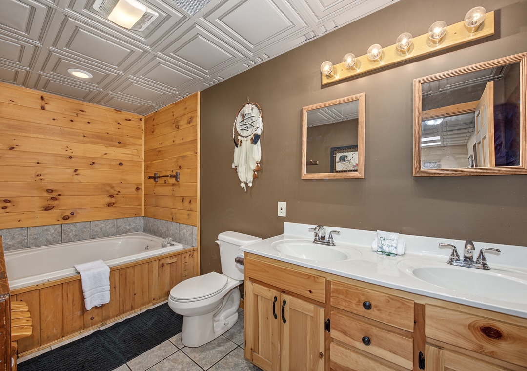 Your private bathroom combines rustic charm with modern comfort. Natural wood accents and warm lighting create a cozy cabin feel, while dual sinks and a soaking tub let you unwind after a day of adventure.