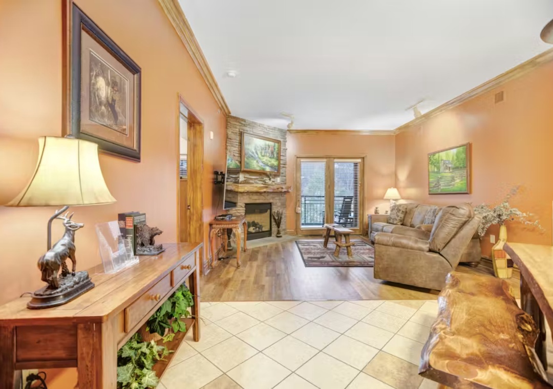 Unwind in your cozy living room with warm leather seating, rustic fireplace, and thoughtful touches that make this space feel like home.