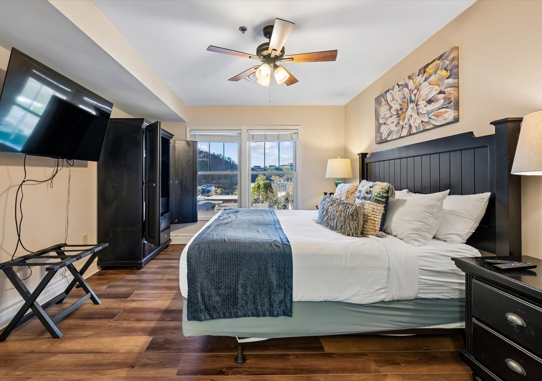 Unwind in your stylish bedroom featuring a plush king bed, large TV for movie nights, and serene city views through bright windows.