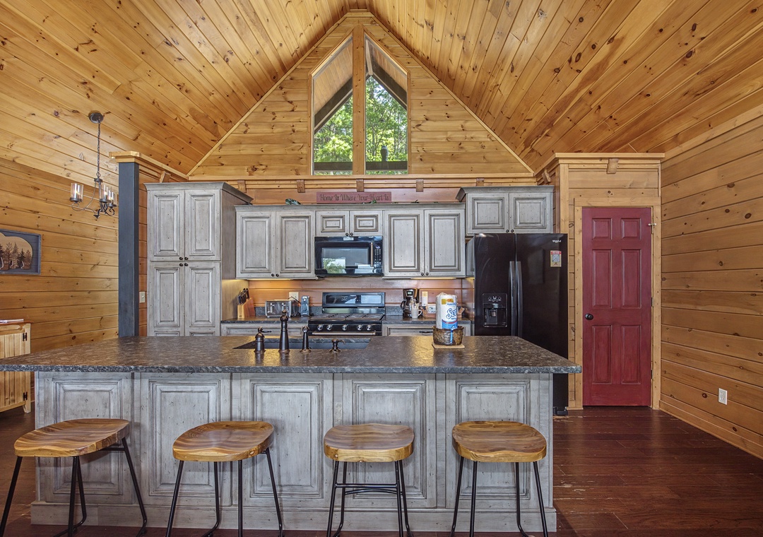 Cook your favorite meals in this rustic kitchen with granite counters, full appliances, and charming wooden bar seating for easy entertaining.