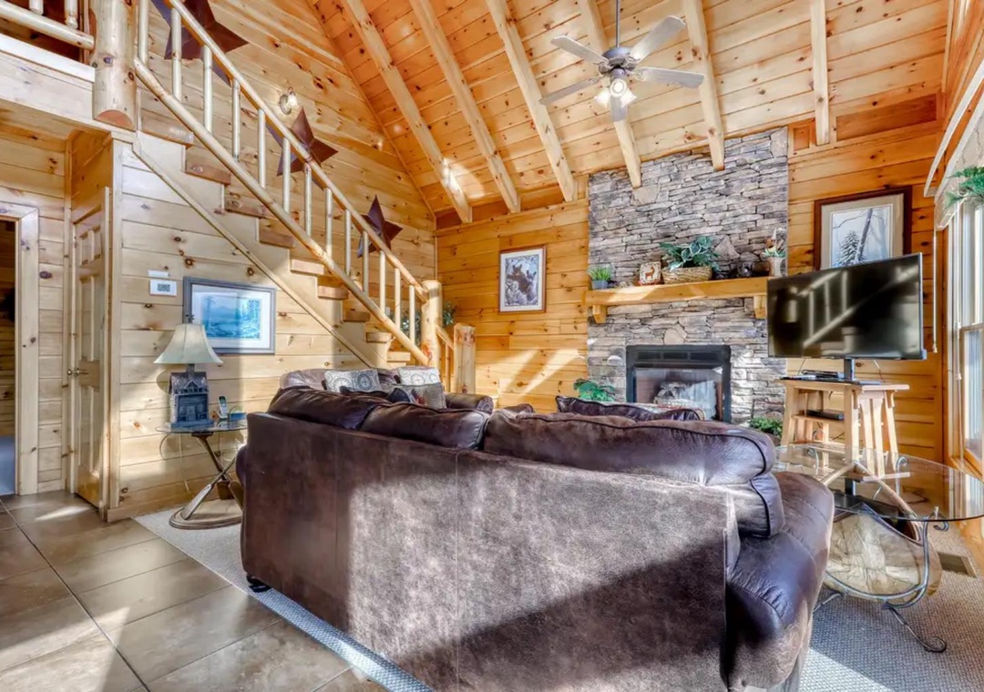 Step into your cozy mountain escape, where soaring wood-beamed ceilings and a stunning stone fireplace create the perfect retreat after a day of adventure.