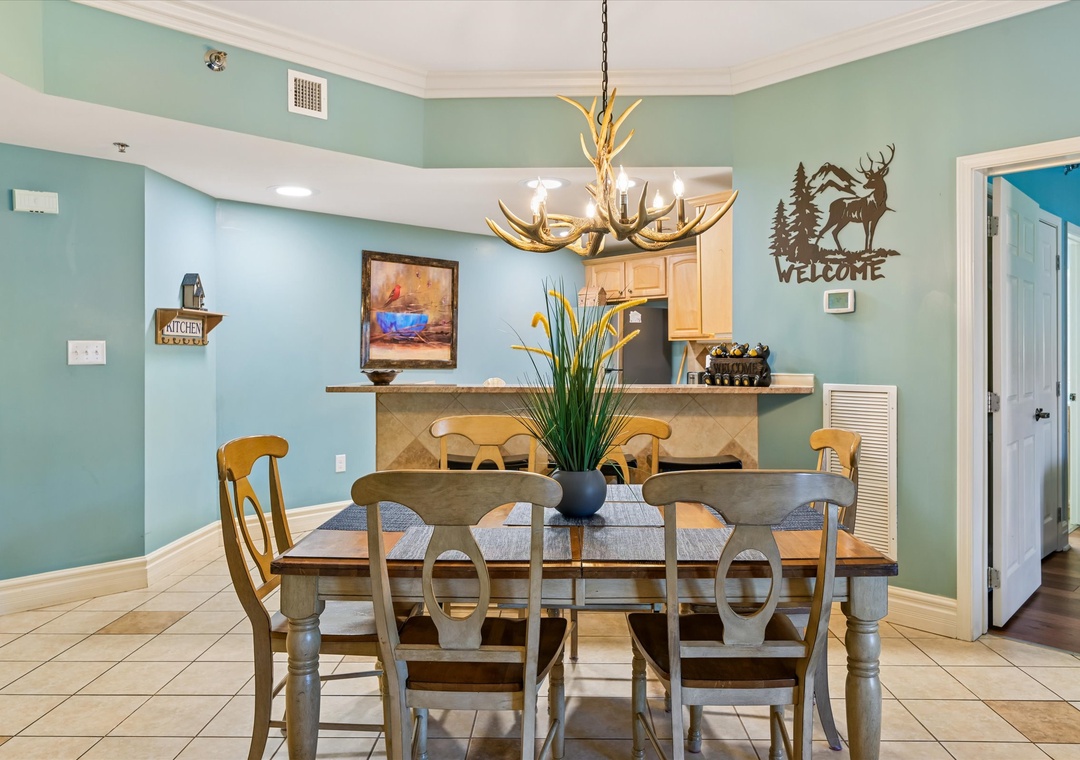 Gather around this welcoming dining table where memorable meals unfold under a rustic antler chandelier in your cozy mountain-inspired retreat.