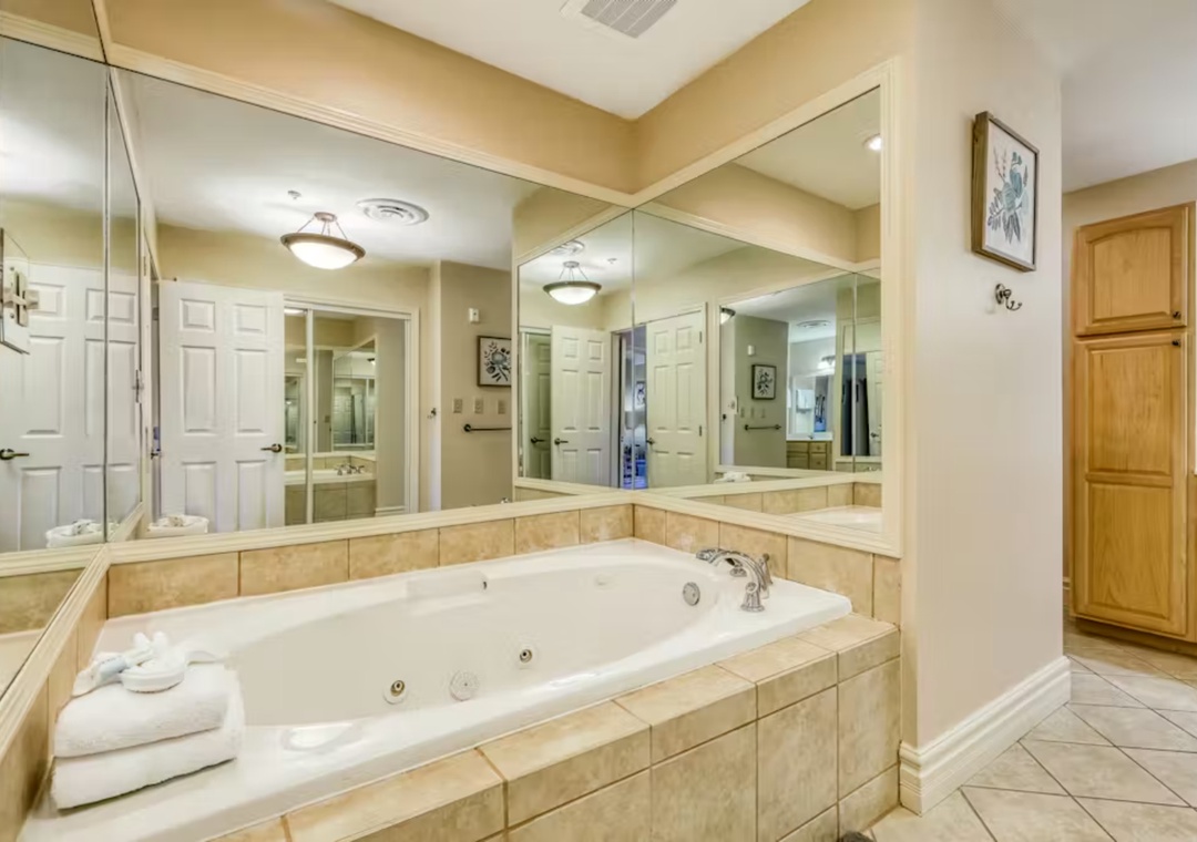 Soak your worries away in this luxurious jetted tub, where mirrored walls create an airy spa-like sanctuary for ultimate relaxation.