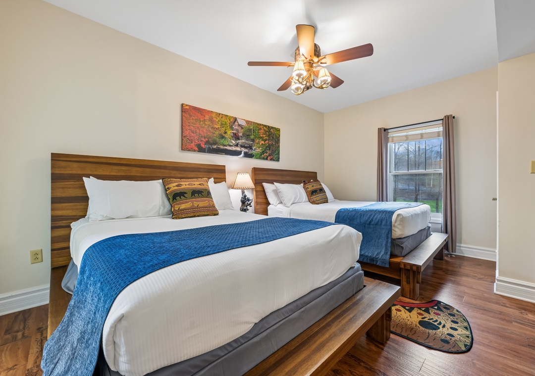 Rest peacefully in your cozy bedroom with comfortable beds, warm wood accents, and serene autumn artwork creating the perfect retreat.