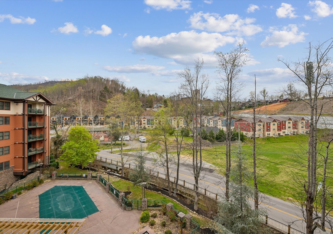 Mountain community view with resort buildings, sports court, and scenic landscape backdrop creating a perfect vacation setting.
