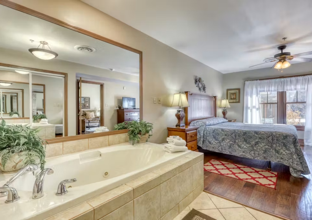 Indulge in your private suite featuring a luxurious jetted tub and spacious bedroom with elegant furnishings for the ultimate romantic retreat.