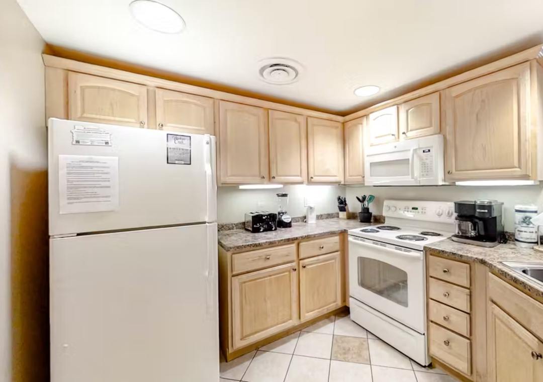 Your fully equipped kitchen awaits with granite countertops, light wood cabinets, and all appliances needed for home-cooked meals.