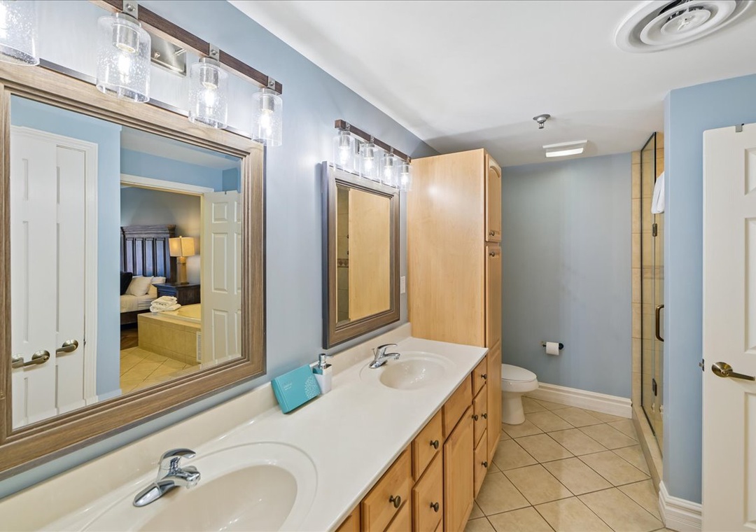 Freshen up in your spacious master bathroom with dual vanities, elegant lighting, and soothing blue tones that create a spa-like retreat.