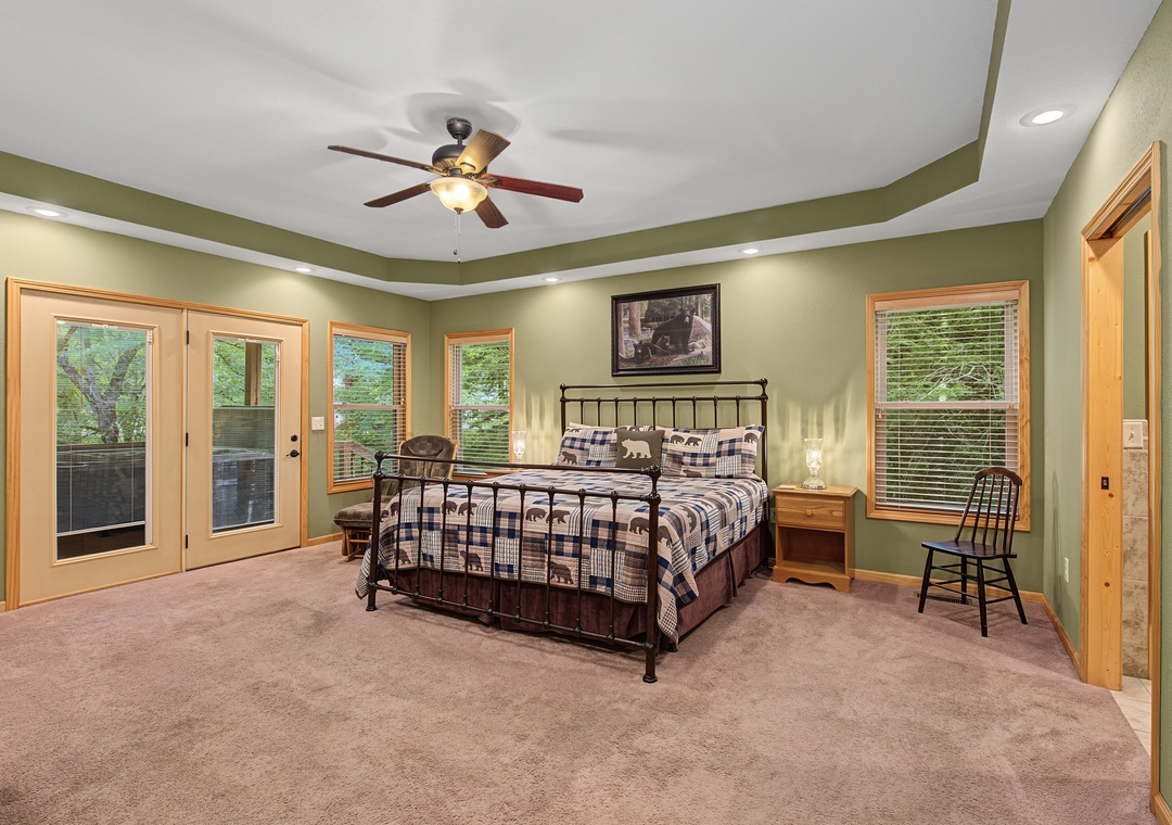 Settle into your spacious bedroom with its inviting king bed, cozy plaid linens, and doors that open directly to your private outdoor space.