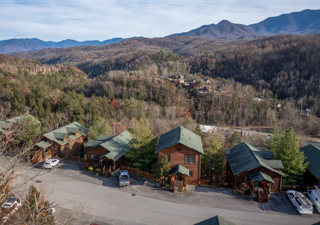Nestled in the Smoky Mountains, these charming cabins offer peaceful mountain surroundings with forested hillsides and stunning seasonal colors. The property provides convenient parking and easy access to the natural beauty of the area.