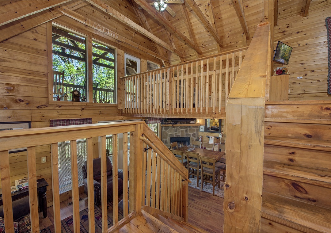 Rustic wooden staircase leads you through this cozy cabin's open layout, where exposed beams and warm wood create your mountain retreat.