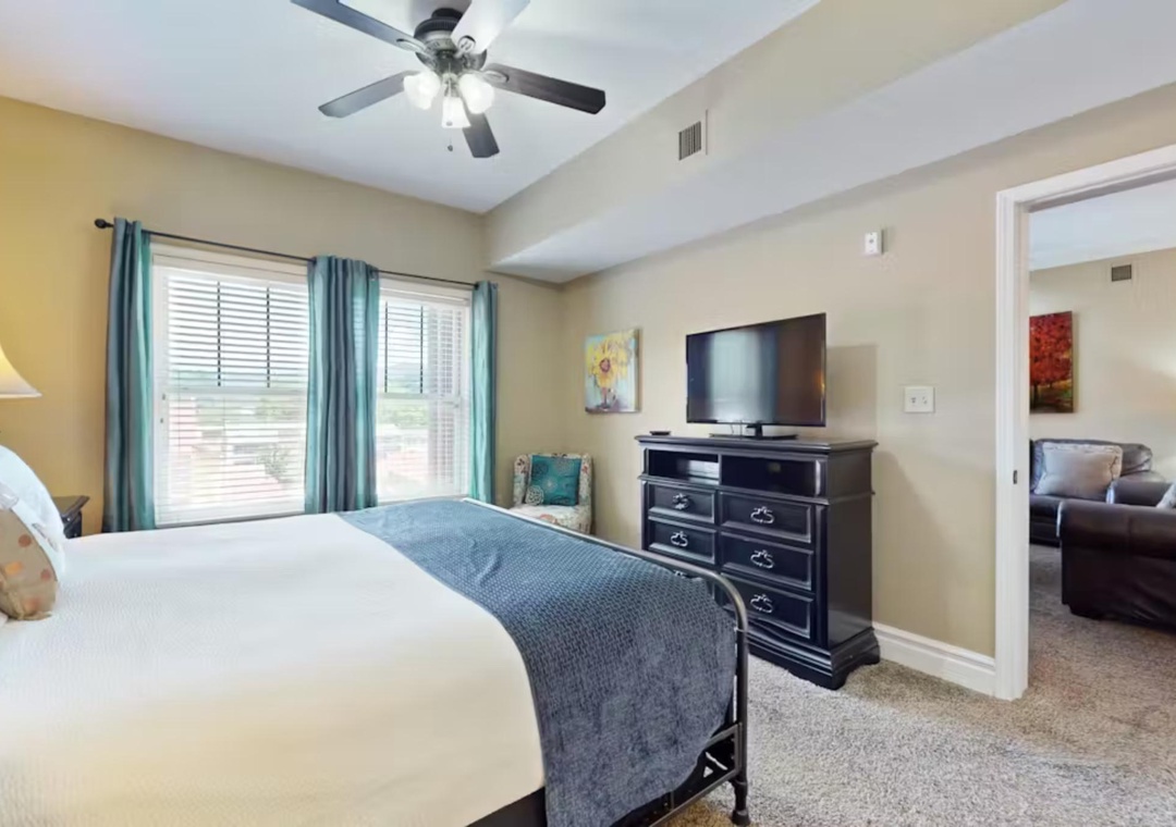Unwind in your spacious bedroom with plush bedding, ceiling fan for comfort, and entertainment center for cozy evenings in.