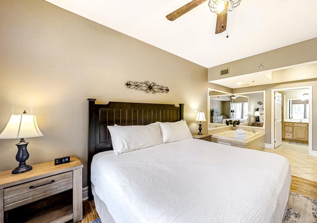 Unwind in your spacious bedroom featuring crisp white linens, rustic wooden beams, and an elegant en-suite bathroom for ultimate comfort.