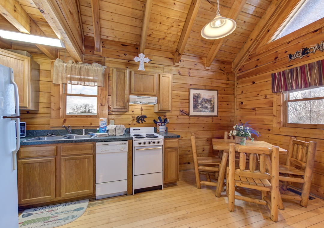 You'll love preparing meals in this cozy log cabin kitchen, where rustic wood beams create a warm atmosphere for cooking together.