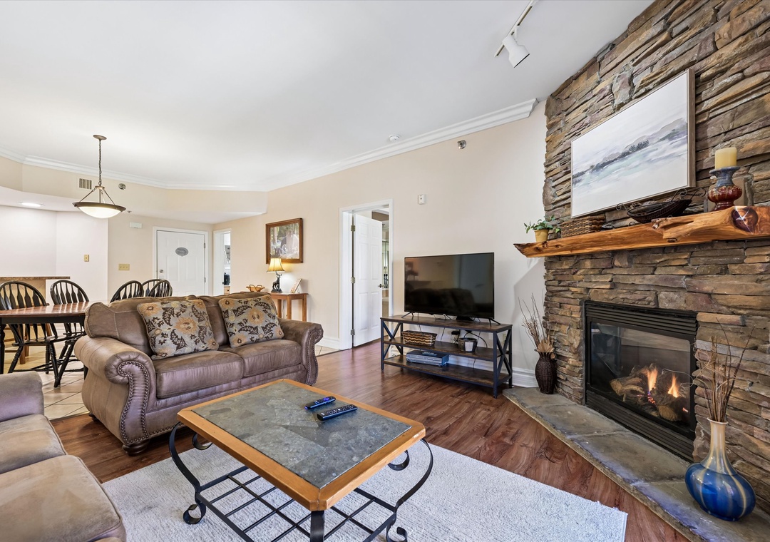 Unwind in your cozy living space where rustic stone fireplace warmth meets modern comfort for perfect evening relaxation.