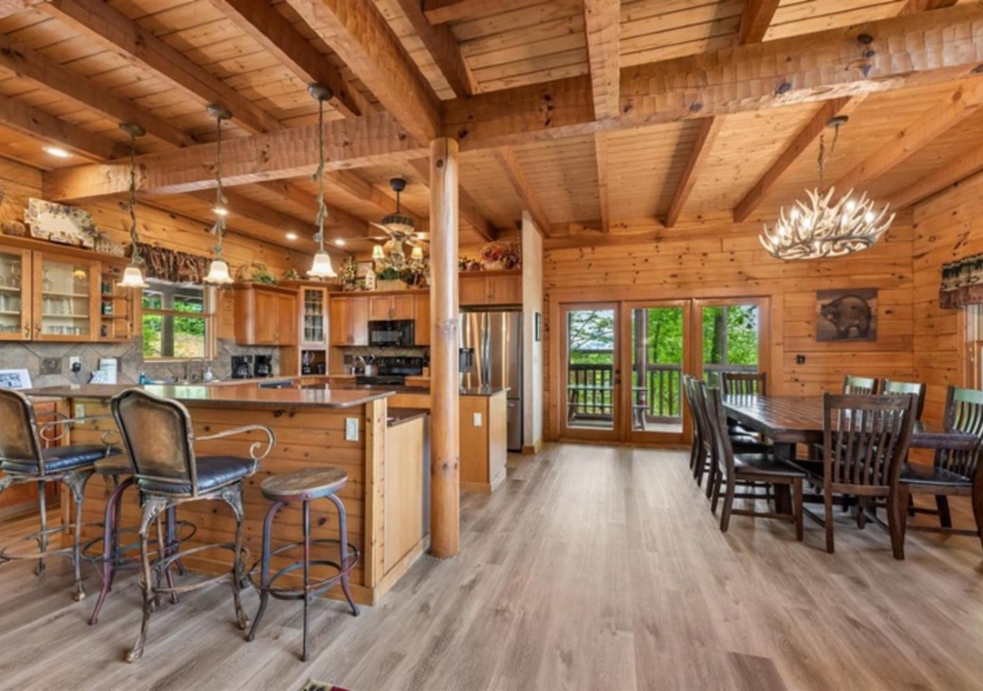 Gather around the spacious kitchen island or settle into the dining nook, where rustic wood beams and abundant natural light create a warm, inviting space for shared meals and lasting memories.