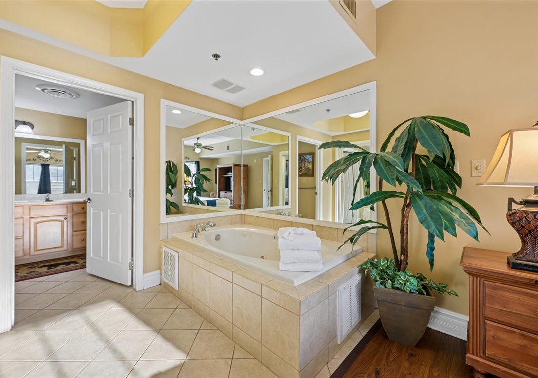 Your luxurious master bathroom features a spacious jetted tub surrounded by warm golden walls, perfect for unwinding after long days exploring.