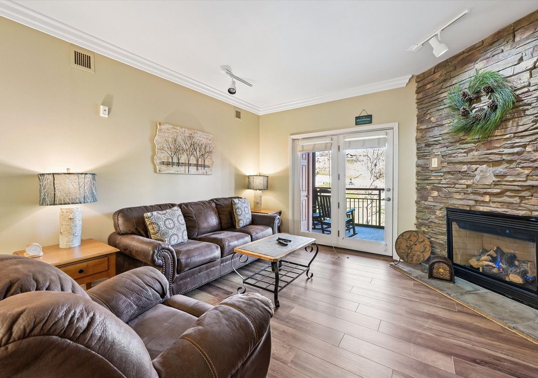 Sink into plush leather sofas by the warm fireplace, where rustic stone meets modern comfort in your perfect retreat.