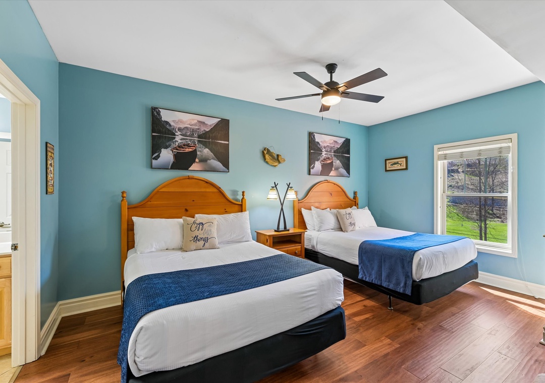 Unwind in your spacious twin bedroom with cozy wood headboards, crisp linens, and peaceful blue walls that create the perfect retreat.