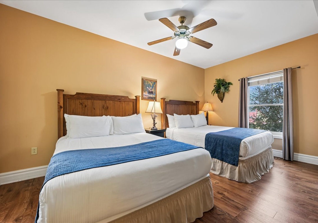 Unwind in your cozy bedroom with two comfortable beds, warm lighting, and peaceful garden views through your window.