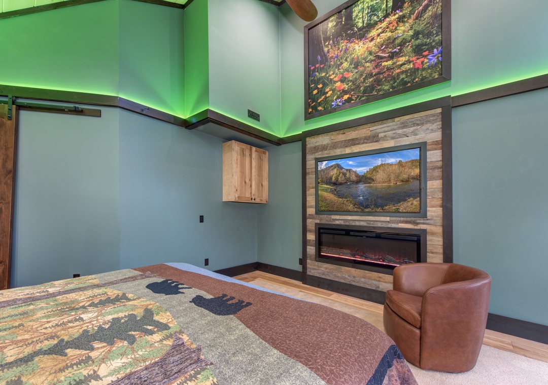 Unwind in your cozy bedroom with ambient lighting, warm fireplace, and plush seating creating the perfect retreat atmosphere.