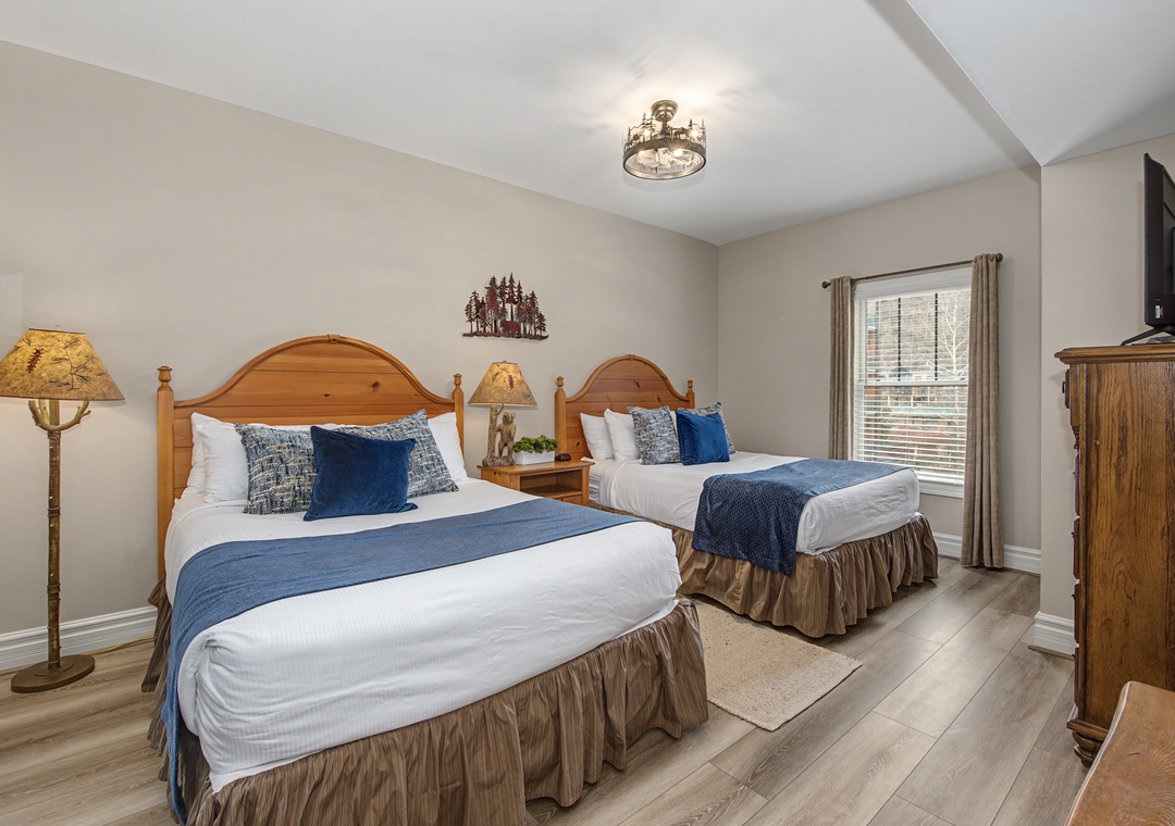 Relax in your twin-bed sanctuary with rustic charm, where soft blue accents and warm wood create the perfect mountain retreat atmosphere.