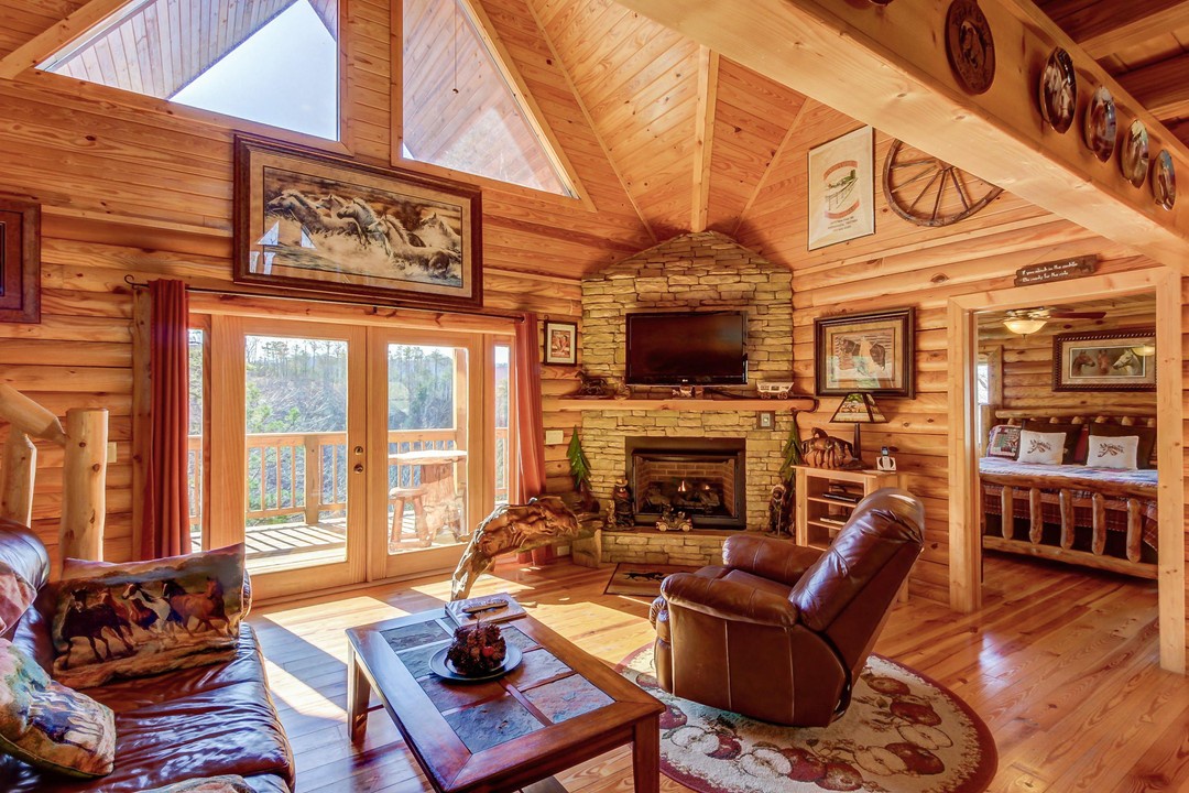 Step into this inviting cabin with soaring cathedral ceilings and abundant natural light. You'll love the warm wood tones, cozy stone fireplace, and seamless access to your private balcony, perfect for morning coffee or evening relaxation.