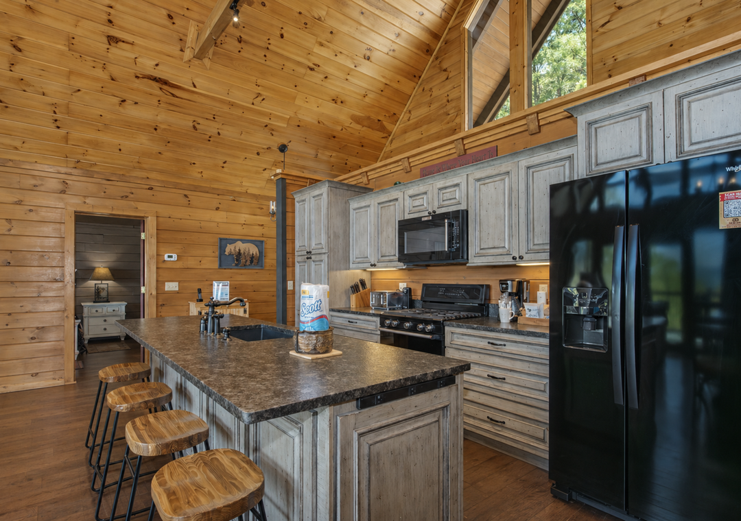 Your fully equipped kitchen features granite countertops, modern appliances, and a spacious island for cooking memorable meals in this warm log cabin setting.