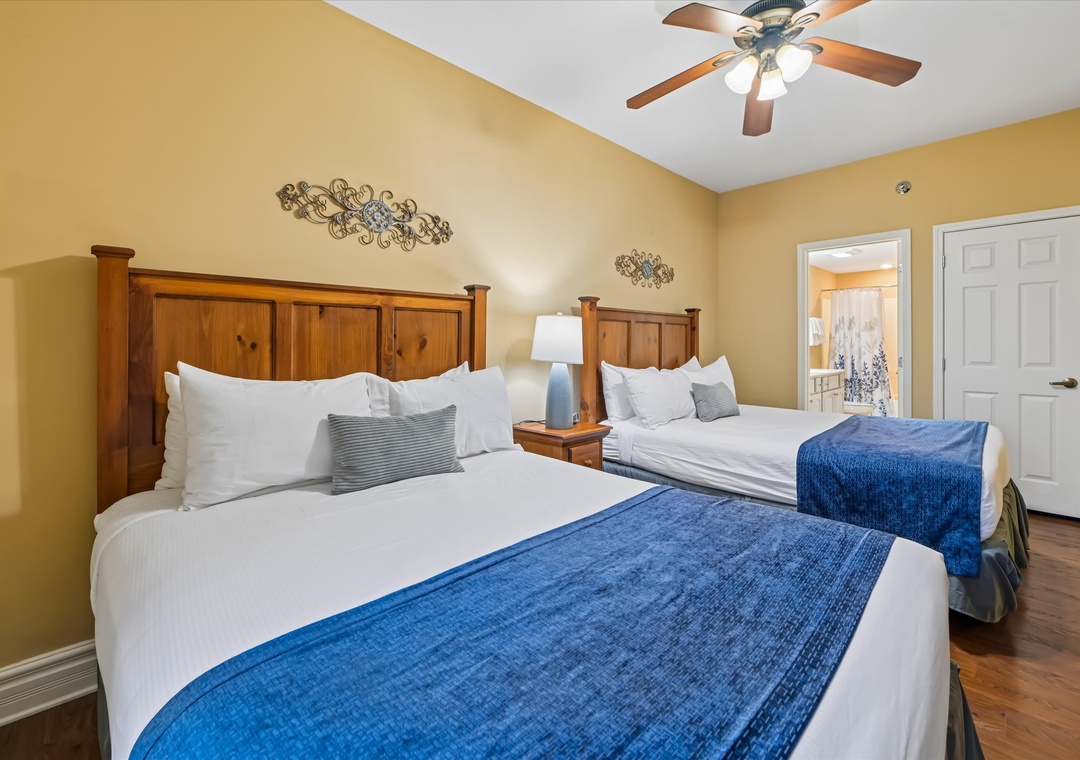 Relax in comfort with two cozy beds featuring plush linens and blue accent throws, perfect for family stays.